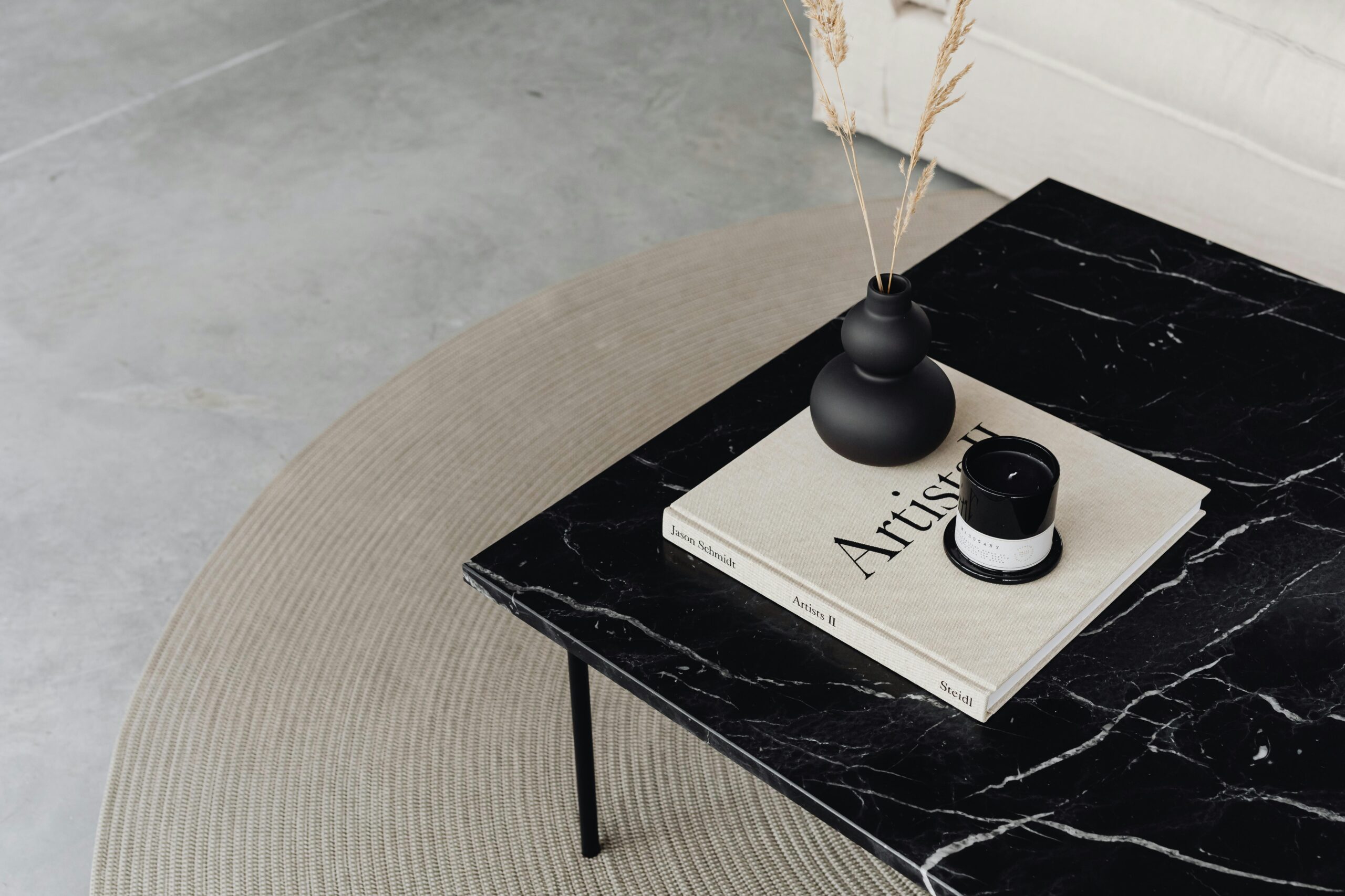 Elegant minimalist interior featuring a black marble coffee table with decor items.